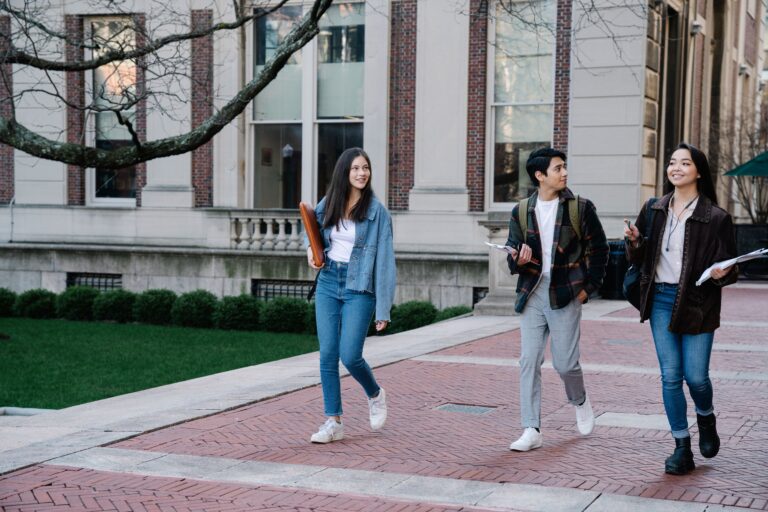 Estudiante en el campus universitario evaluando opciones de préstamos estudiantiles