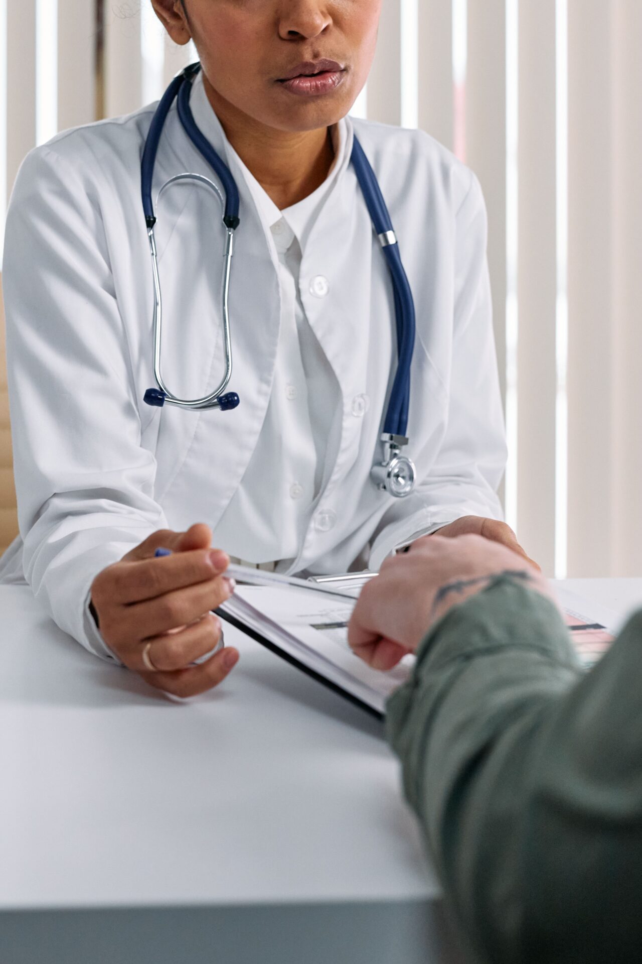 Médico consultando a un paciente inmigrante sobre su cobertura de Medicaid